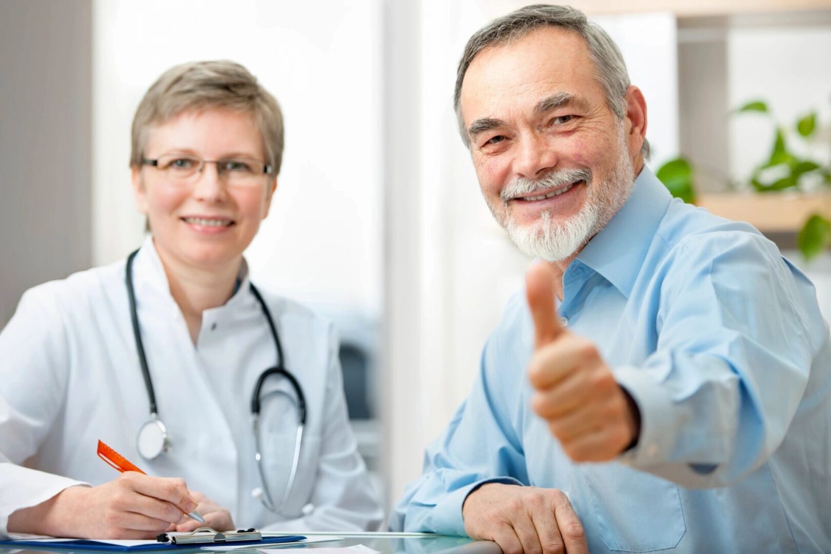 A man and woman sitting at a table with a thumbs up.