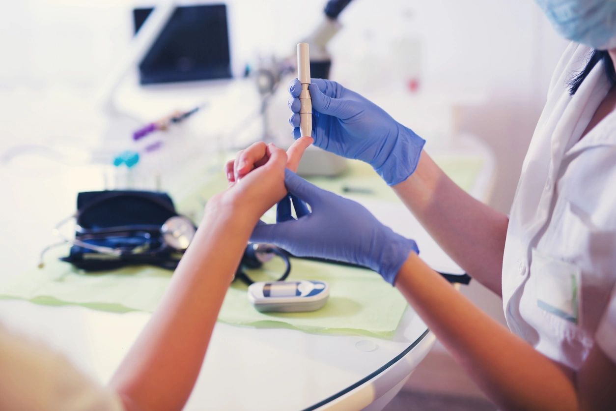 A person in blue gloves holding something on top of a table.